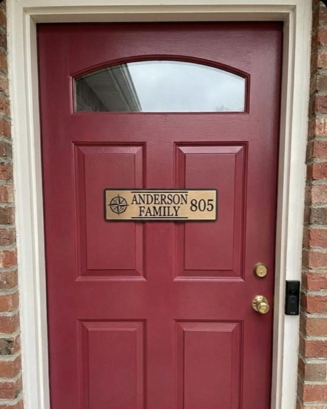 A burgundy front door with a small window at the top.