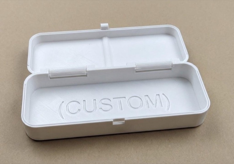 An open, white rectangular box with a hinged lid. The word "(CUSTOM)" is embossed inside the box.