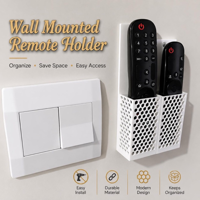A white wall-mounted remote holder with a honeycomb pattern, featuring two compartments holding black remote controls.