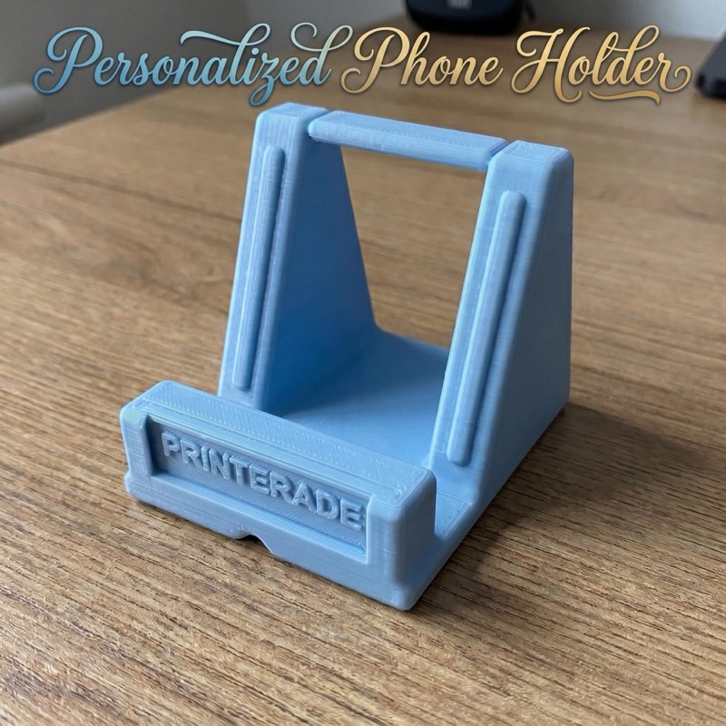 A light blue 3D printed phone holder with a triangular frame and a horizontal support bar.